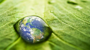 world reflected in water droplet on leaf